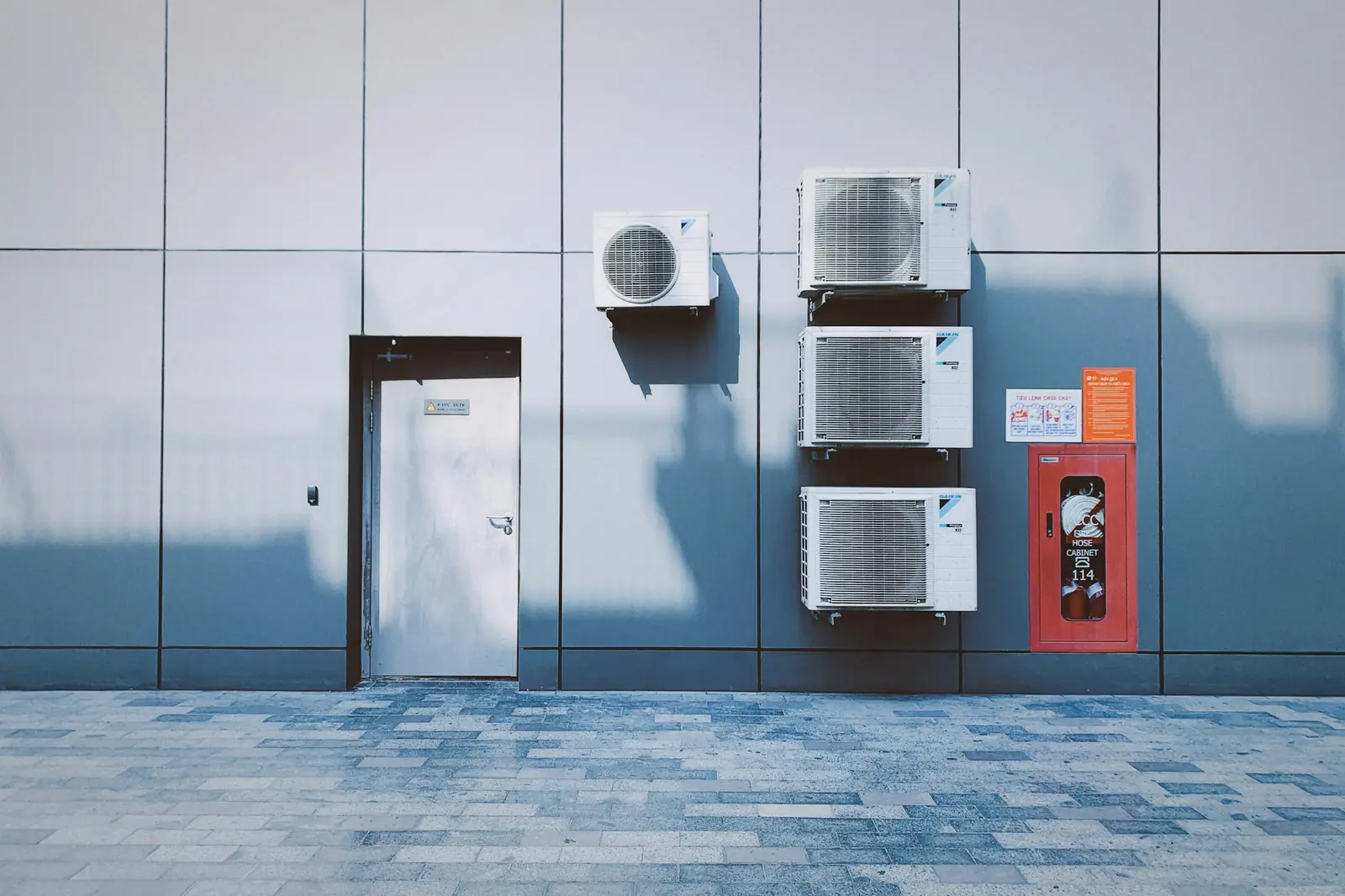 Air conditioning outdoor units mounted on the wall of a modern building